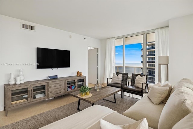 living area featuring visible vents and floor to ceiling windows