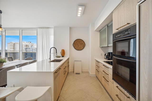 kitchen featuring a sink, black appliances, and light brown cabinetry