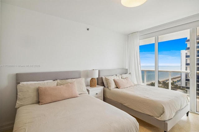 bedroom featuring expansive windows and a water view