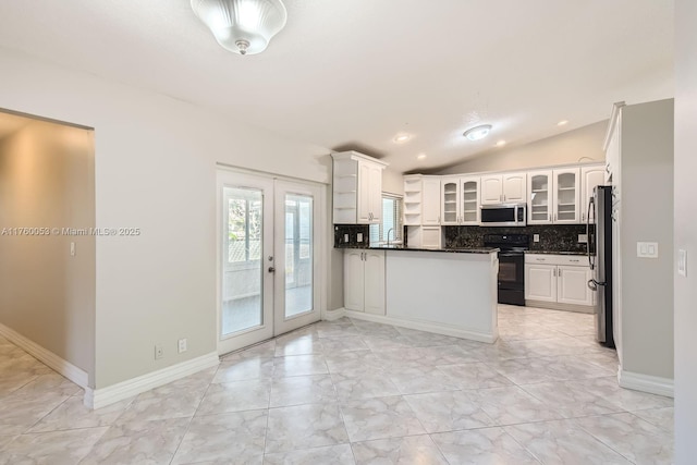 kitchen featuring dark countertops, vaulted ceiling, decorative backsplash, appliances with stainless steel finishes, and a peninsula