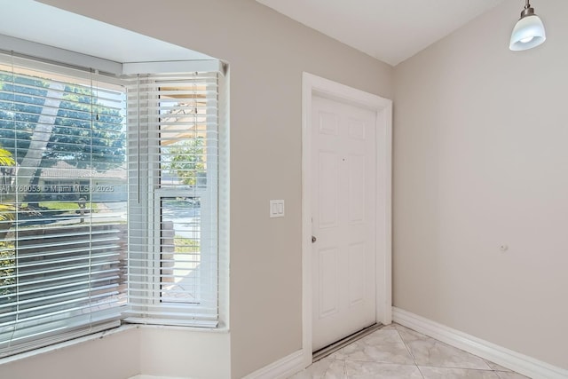 foyer entrance featuring baseboards and marble finish floor