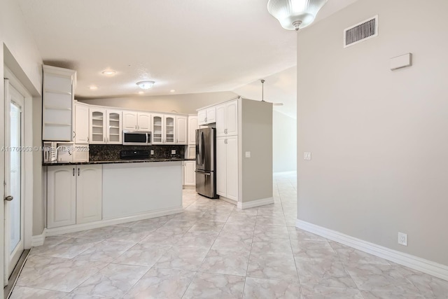 kitchen featuring dark countertops, visible vents, vaulted ceiling, a peninsula, and stainless steel appliances