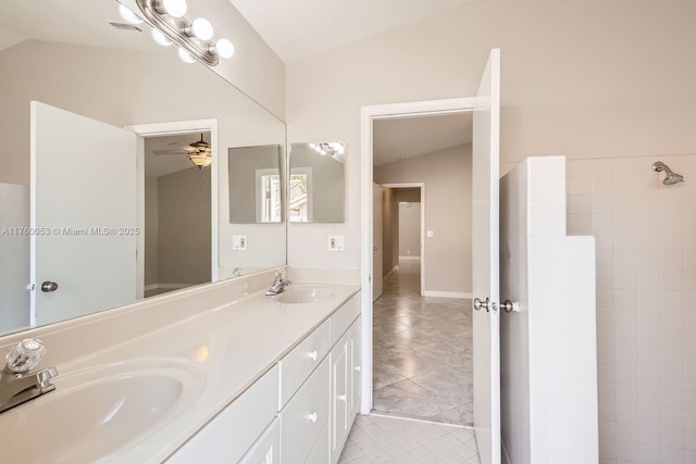 bathroom featuring vaulted ceiling, double vanity, visible vents, and a sink