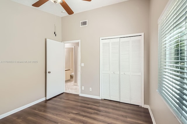 unfurnished bedroom with visible vents, baseboards, a closet, a ceiling fan, and dark wood-style flooring