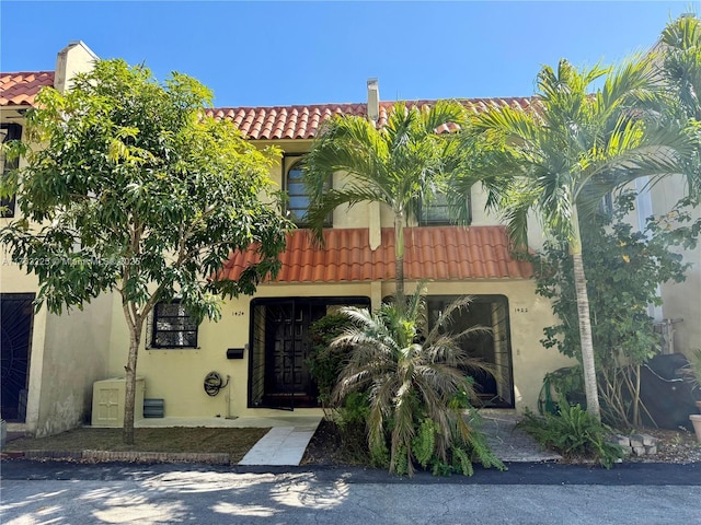 mediterranean / spanish home with stucco siding and a tiled roof