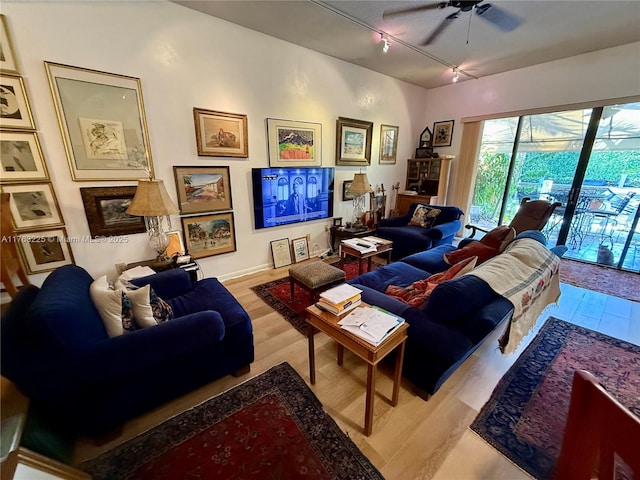 living area with a ceiling fan, track lighting, and wood finished floors