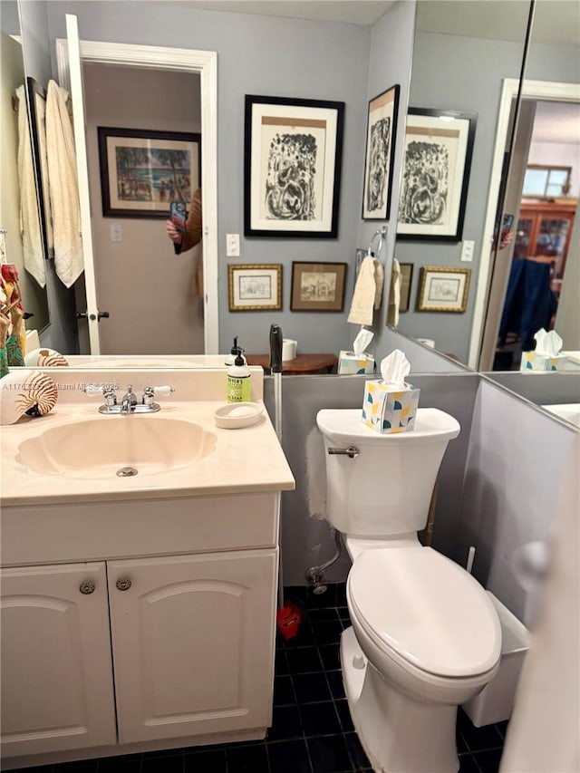 half bath with vanity, tile patterned floors, and toilet