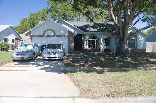 ranch-style house with an attached garage, concrete driveway, and a front yard