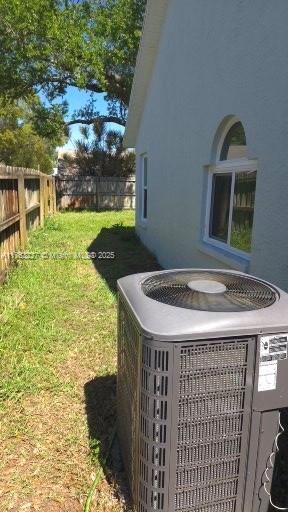 details featuring a fenced backyard, central AC, and stucco siding