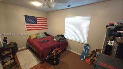 bedroom with visible vents, baseboards, and ceiling fan