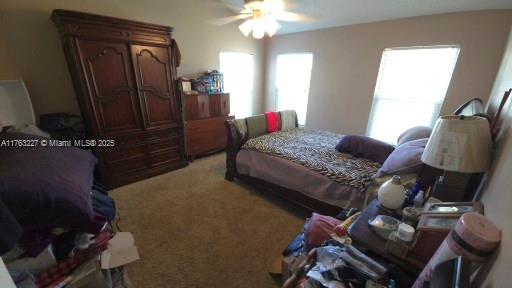 bedroom featuring light colored carpet and ceiling fan