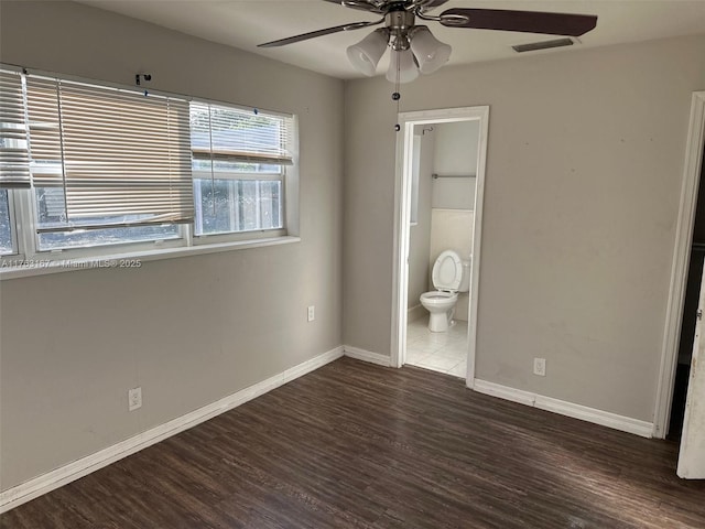 unfurnished bedroom with visible vents, ceiling fan, baseboards, ensuite bathroom, and wood finished floors