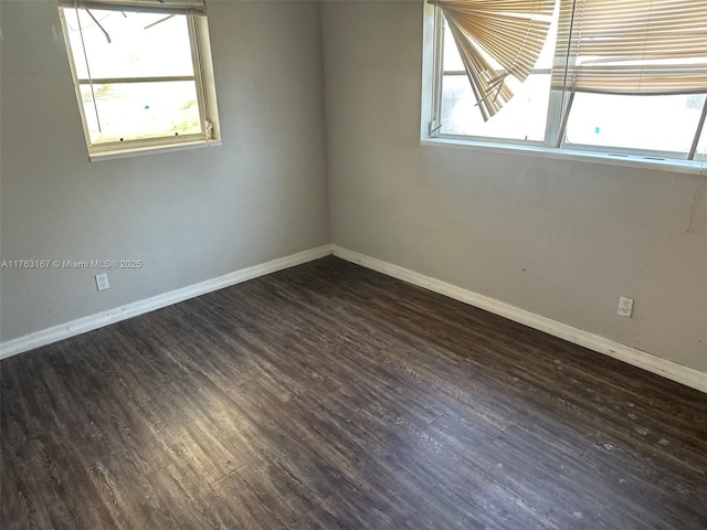 unfurnished room featuring baseboards and wood finished floors