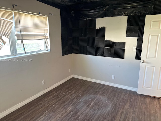 empty room featuring baseboards and wood finished floors