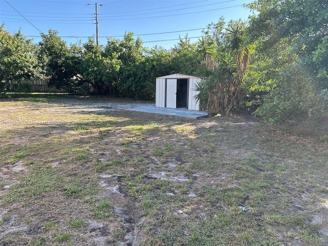 view of yard with an outbuilding, a shed, and fence