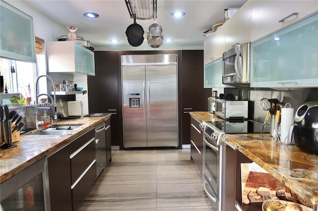 kitchen featuring recessed lighting, a sink, wine cooler, appliances with stainless steel finishes, and modern cabinets