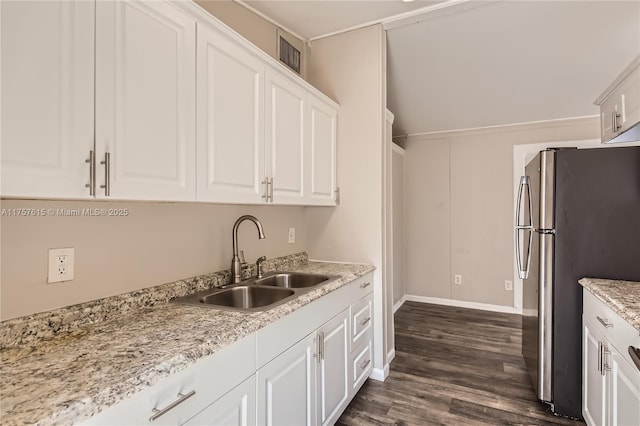 kitchen featuring visible vents, a sink, white cabinetry, freestanding refrigerator, and dark wood-style flooring