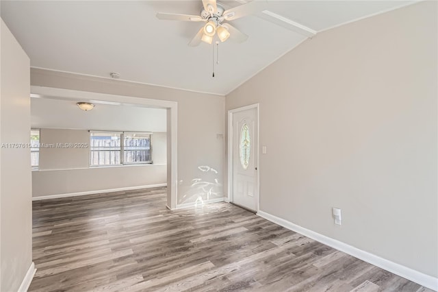 interior space with baseboards, lofted ceiling, and wood finished floors