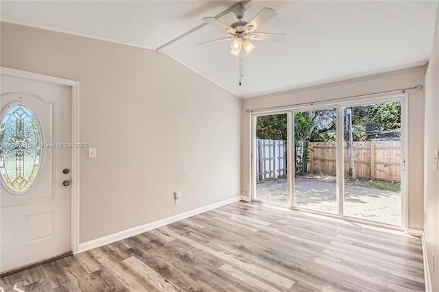 entrance foyer featuring baseboards, light wood-style flooring, a ceiling fan, and vaulted ceiling