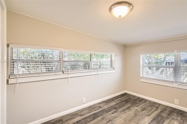 unfurnished room with dark wood-style floors, baseboards, and lofted ceiling