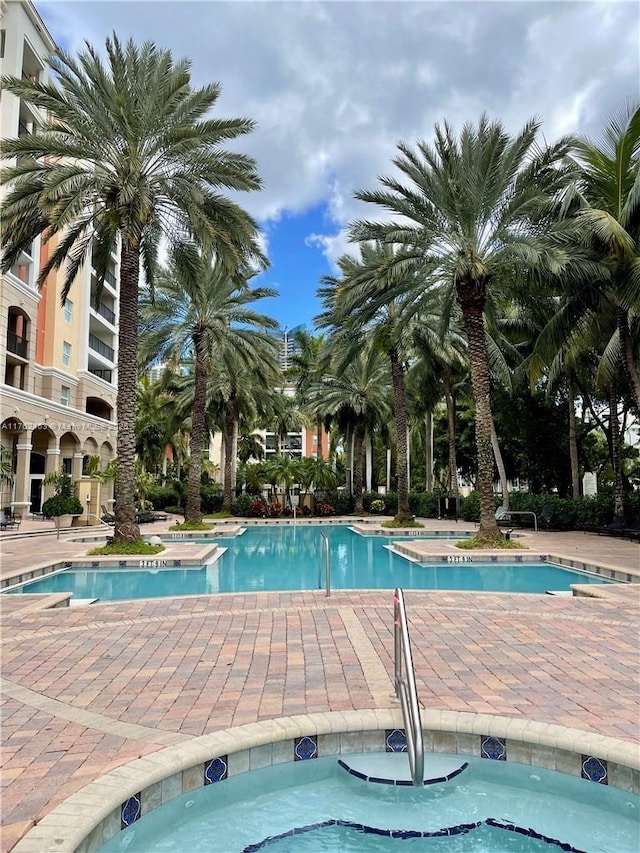 pool with a community hot tub and a patio