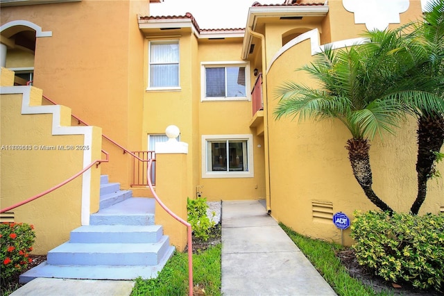 doorway to property with stucco siding and a tile roof