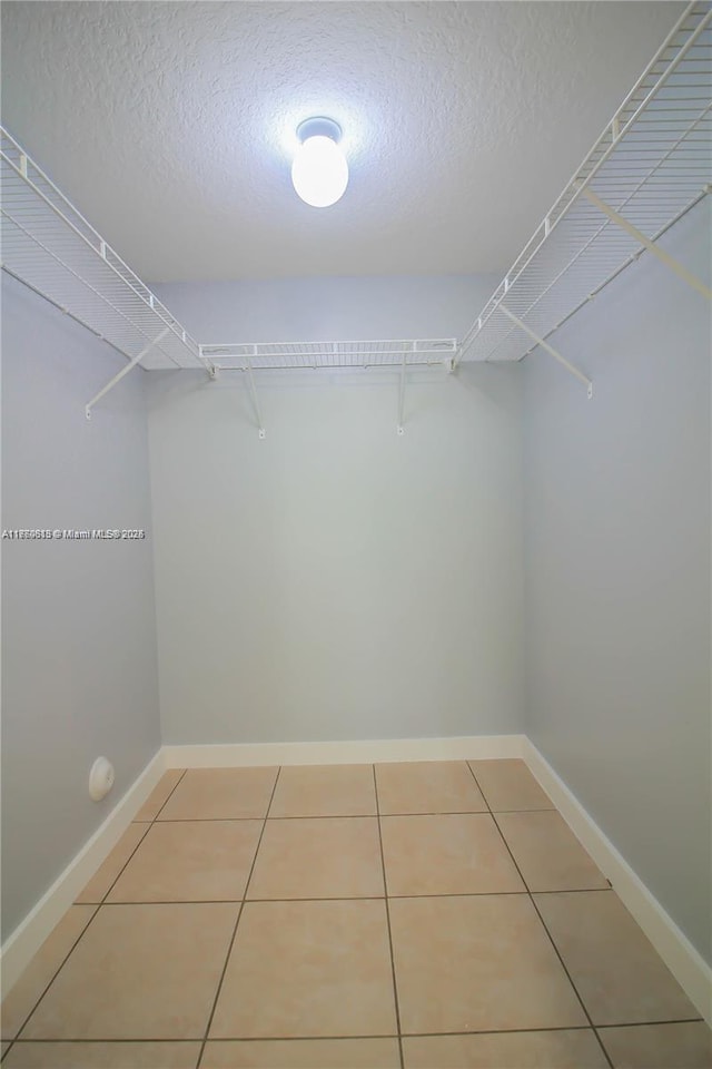 walk in closet with tile patterned flooring