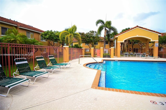 community pool featuring a patio area and fence