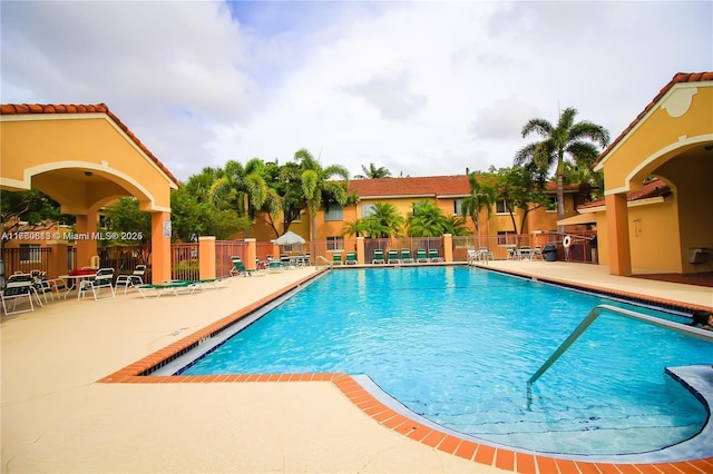 community pool featuring a patio area and fence