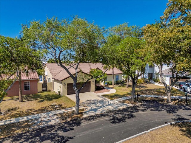 19922 NW 88th Ave, Hialeah, FL 33018 - mediterranean / spanish-style home featuring stucco siding, a tile roof, a garage, concrete driveway, and a front yard