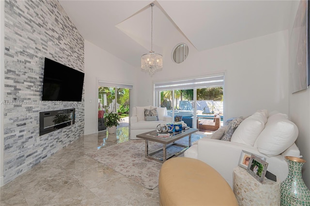 living area with marble finish floor, high vaulted ceiling, an inviting chandelier, and a fireplace