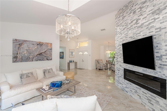 living area featuring visible vents, marble finish floor, a notable chandelier, and a stone fireplace