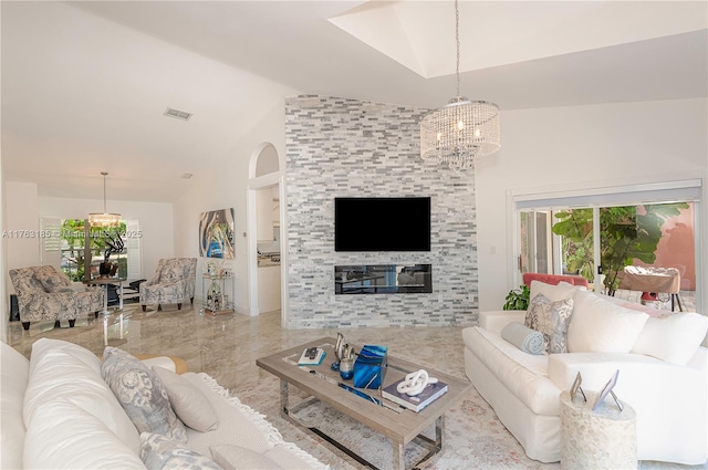 living room with lofted ceiling, a fireplace, visible vents, and a chandelier