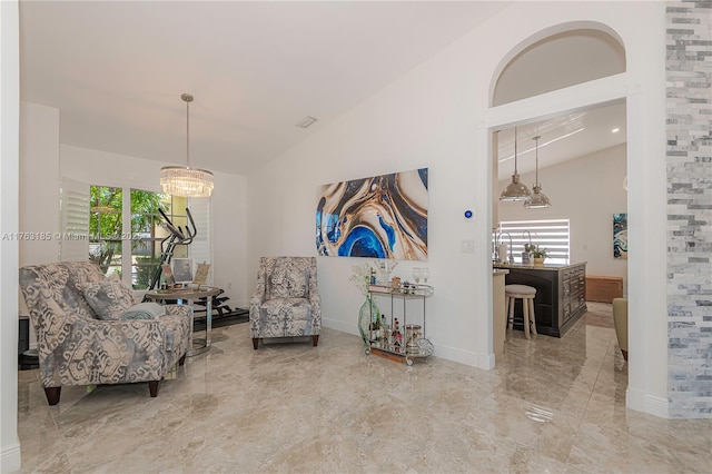 sitting room with baseboards, high vaulted ceiling, and an inviting chandelier