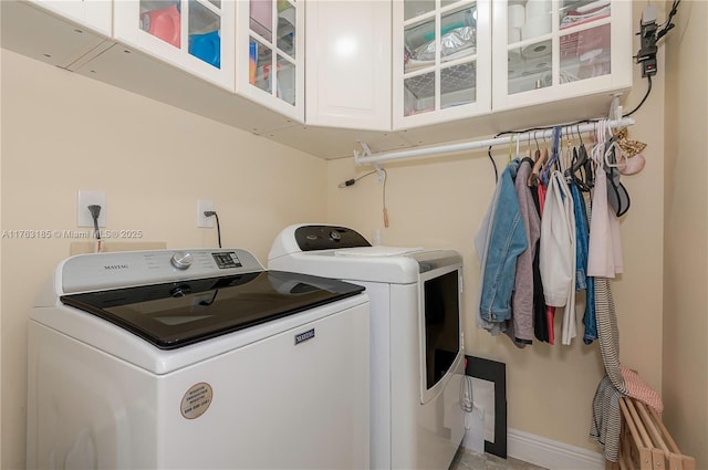 laundry room featuring cabinet space, washer and dryer, and baseboards