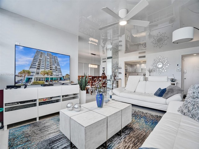 living area with a high ceiling and ceiling fan