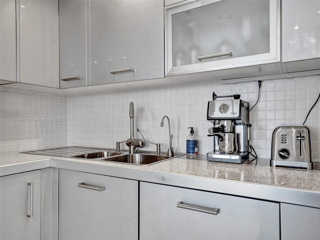 kitchen featuring white cabinetry, light countertops, and a sink