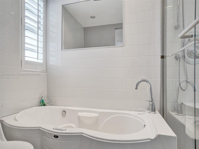 full bathroom featuring tile walls and a bath