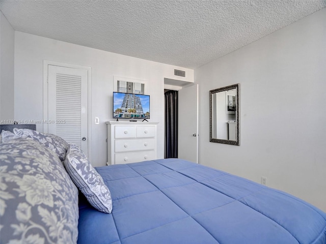 bedroom featuring visible vents and a textured ceiling