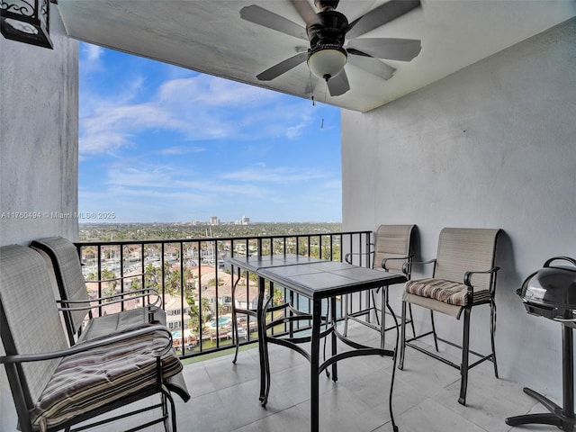 balcony featuring a view of city and a ceiling fan