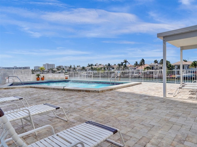 community pool with a patio and fence