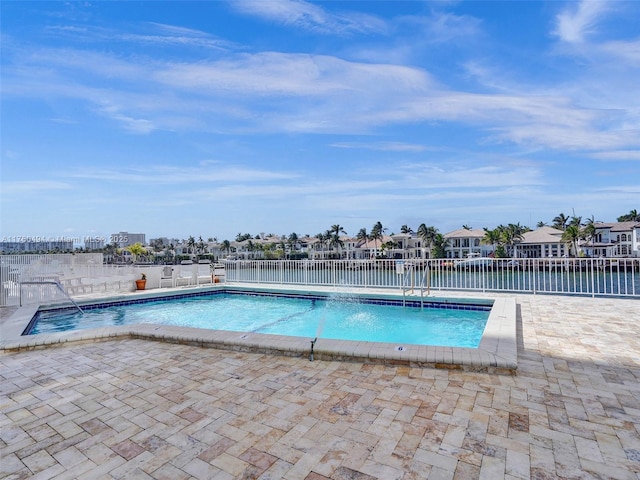 pool with a patio area and fence