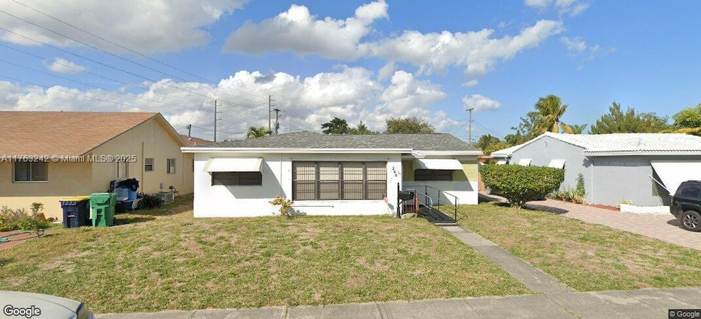 single story home with stucco siding and a front yard