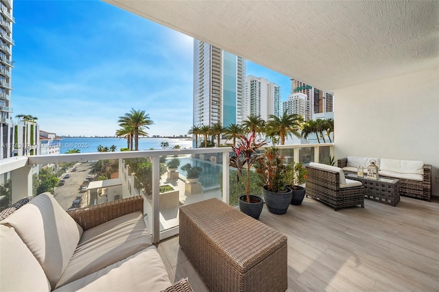 balcony featuring an outdoor living space and a water view