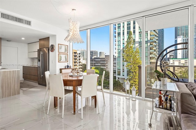 dining room with visible vents, a view of city, marble finish floor, floor to ceiling windows, and a chandelier