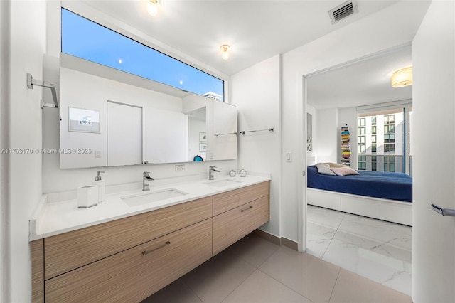 bathroom with a sink, visible vents, double vanity, and ensuite bathroom