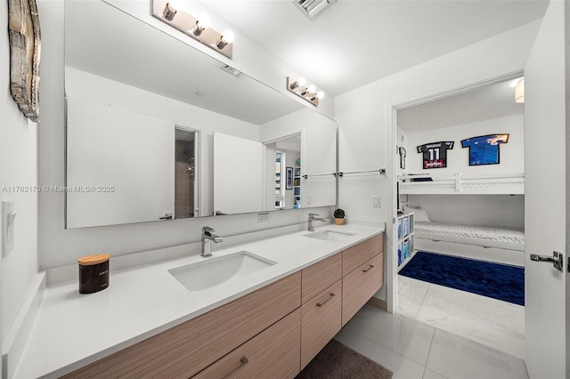 bathroom with double vanity, visible vents, and a sink