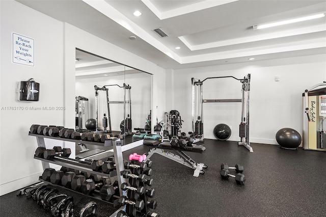 gym with visible vents, recessed lighting, baseboards, and a tray ceiling