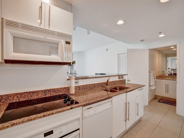 kitchen featuring a sink, light stone counters, white appliances, white cabinets, and light tile patterned floors