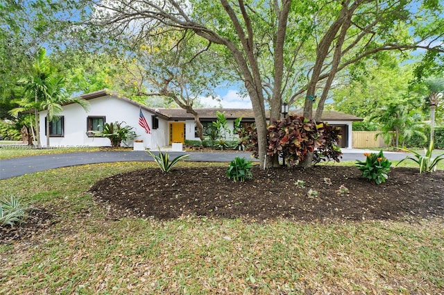 ranch-style home featuring aphalt driveway, a garage, and stucco siding